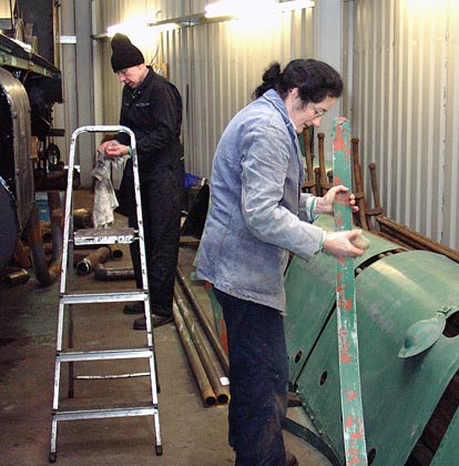 Chris Brown (left) and Alex Hayes work on preparing bits and piece for painting. Alex is working on a boiler band. January 03 2004