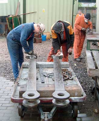Huw Button (left) and Steve Underhill work on the rear coupling rods. In the background Keith Clarke cleans one of the backhead fittings. May 08 2004 &copy; Colin Henderson 