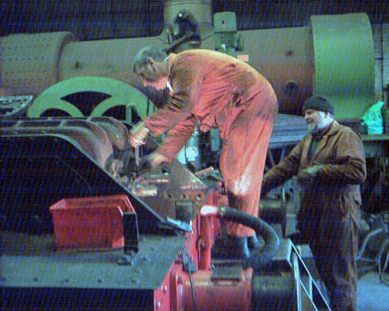 In the shed Keith Lines undoes a nut holding the valve cover in position advised by Colin Henderson. March 8 2003 &copy; John Salter