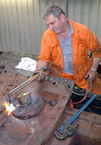Keith Lines heats up the centre cylinder casting to remove a stud. This is the inlet side. The steam pipe from the superheater headed connects here. July 19 2003 &copy; Colin Henderson