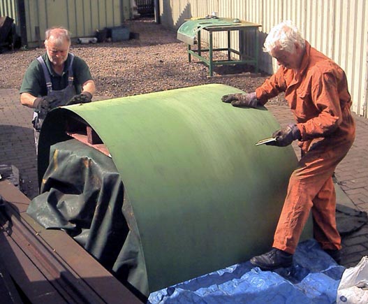 Brian Dodd (left) and Bob Robson rub down a primed cladding sheet before giving it a second coat. July 27 2003. &copy; John Salter