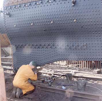 Colin Jeffrey, as close to the footplate as it is currently possible to get, works on the studs for mounting the ashpan to the firebox. March 23 2003. &copy; Martyn Bane