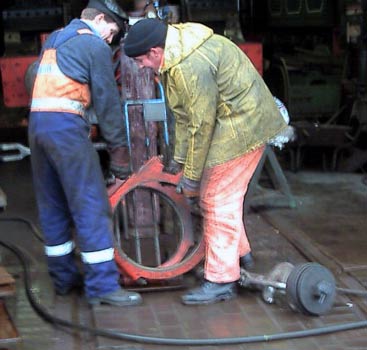 Your webmaster and Leon Salter manhandle the eccentric straps. On the ground, to the right, is the front drawhook. March 8 2003 &copy; John Salter
