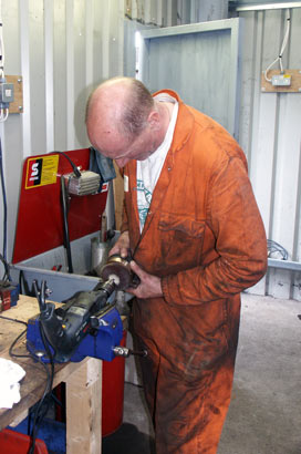 Steve Underhill works on one of the gland packing brasses. This one fits on the left hand outside piston rod. July 27 2003