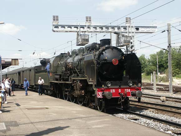 The superb Chapelonised Etat/SNCF Ouest system Pacific 231G558, steam locomotive for 'The Alsace Lorraine Express' waits to be overtaken by a pair electric hauled, Strasbourg line, expresses at Ch&acirc;lons-en-Champagne. May 28 2003