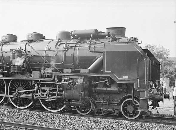 A good view of the front end detail of 231G558 showing the valvegear arrangement, the cross compound air pump, mechanical lubricator and part of the ACFI feedwater heating system. The drum on this side recieves the exhaust steam, cold water and mixes them. Also note the bogie brakes. June 1 2003