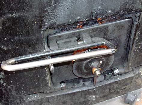 Hawk's firehole door opens out and down. This loco lacks the secondary air ducting of the other locos but does have a deflector plate on the fire side of the door. April 12 2004