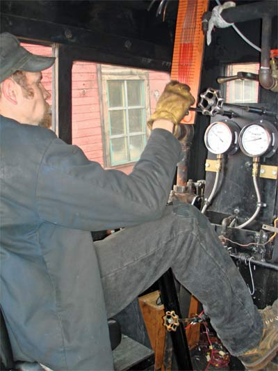 Fireman Mark Sodergren adjusts the atomising steam during testing. Note the manometer in front of him measuring vacuum levels at various points on the locomotive. © Nigel Day