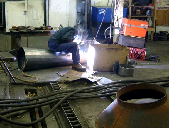 The diffuser, which is being used as a seat, gets welded to the mixing chamber. October 19 2003 Courtesy of Nigel Day