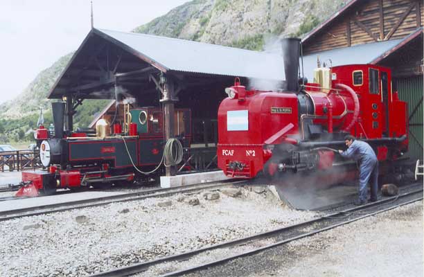 Winson built 2-6-2T FCAF No.3 Camila (left) stands in No.2 road 'Estacion Fin del Mundo' during a layover between duties. KM Class Garratt 0-4-0+0-4-0 FCAF No.2 'Ing. L.D.Porta' stands over the pit outside the workshops. See above for a view of No.2 in original condition. No.2 is being given a routine inspection and pressure wash. Both locos sport many modifications, perhaps the most prominent being the Lempor tapered chimneys and on No.2 the curved main steam pipe behind the dome. January 14 2003 © Shaun McMahon