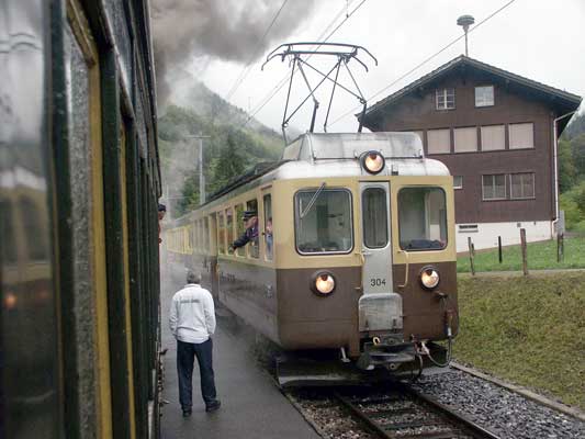 An Interlaken Oct bound electric passes the steam hauled special at a station south of Zweilütschinen. October 5 2003