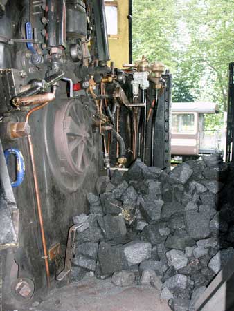 With half the coal on the cab floor the very Swiss firehole door and a number of controls can be seen on 1067. October 5 2003