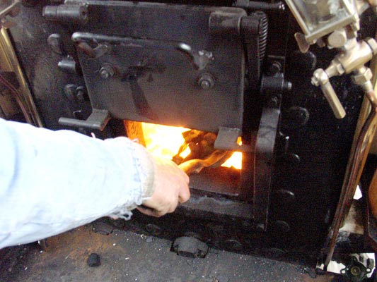 Being single manned the driver also fires. With the firehole door raised a round of coal is added to the fire. April 11 2004